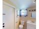 Bright bathroom with a tiled floor, white toilet, vanity, window with curtain, and mirror at 21456 Holdern Ave, Port Charlotte, FL 33952