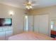 Bedroom featuring closet, ceiling fan and TV on storage drawers at 21456 Holdern Ave, Port Charlotte, FL 33952