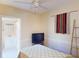 Bedroom showcasing ceiling fan and ensuite bathroom at 21456 Holdern Ave, Port Charlotte, FL 33952