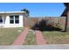 A view of the driveway of the home, surrounded by green grass and trees at 21456 Holdern Ave, Port Charlotte, FL 33952