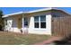Charming home with a cheerful yellow door and a small seating area on the front porch at 21456 Holdern Ave, Port Charlotte, FL 33952
