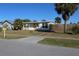 A single-story home with a yellow door, well-manicured lawn, and a charming fence at 21456 Holdern Ave, Port Charlotte, FL 33952