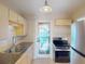 Well-lit kitchen featuring light cabinets, stainless steel appliances, and a charming door to the outside at 21456 Holdern Ave, Port Charlotte, FL 33952
