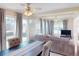 Cozy living room and dining area with a ceiling fan, neutral tones, and large windows with natural light at 21456 Holdern Ave, Port Charlotte, FL 33952
