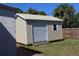 A backyard shed features horizontal siding and an over-sized roll-up door at 21456 Holdern Ave, Port Charlotte, FL 33952