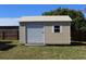 A backyard shed features horizontal siding and an over-sized roll-up door at 21456 Holdern Ave, Port Charlotte, FL 33952