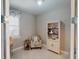 Cozy room featuring tiled floors, neutral paint, a charming bookcase, and a window with coastal-themed décor at 2478 Brassica Dr, North Port, FL 34289