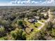 An aerial view of a charming single-story home with a large yard and ample greenery at 27385 Neaptide Dr, Punta Gorda, FL 33983
