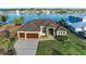 Stunning waterfront home featuring a two-car garage and a paved driveway surrounded by lush landscaping at 349 Springview Nw Cir, Port Charlotte, FL 33948
