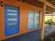 Striking blue front door with glass panels and orange siding at 520 Sharon Cir, Port Charlotte, FL 33952