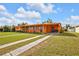 Single story home with a lush lawn and a vibrant orange facade at 520 Sharon Cir, Port Charlotte, FL 33952