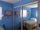 Cozy bedroom featuring blue walls, mirrored closet doors and a comfortable twin bed at 5233 Palena Blvd, North Port, FL 34287