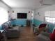 Another view of living room featuring a comfortable sofa, large window, and modern television at 5233 Palena Blvd, North Port, FL 34287