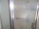 Close-up of textured shower door with chrome trim and a modern handle at 5233 Palena Blvd, North Port, FL 34287