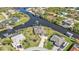 Stunning aerial view of the home, waterfront, boat docks, pool, lush landscaping, and neighborhood at 9428 Bandera Ln, Port Charlotte, FL 33981
