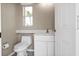 Bright bathroom featuring a toilet, sink vanity, and a window for natural light at 9428 Bandera Ln, Port Charlotte, FL 33981