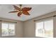 Comfortable bedroom featuring two large windows for natural light, and a leaf-inspired ceiling fan adding warmth at 9428 Bandera Ln, Port Charlotte, FL 33981