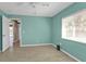 Inviting turquoise bedroom offers a serene atmosphere with light wood floors and ample natural light from a bright window at 9428 Bandera Ln, Port Charlotte, FL 33981