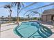 Inviting screened-in pool area offers a relaxing retreat overlooking a tranquil waterway and lush palm trees, perfect for outdoor enjoyment at 9428 Bandera Ln, Port Charlotte, FL 33981