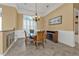 Dining room with a wood table, elegant chandelier, white wainscoting, and neutral tan walls at 960 Messina Dr, Punta Gorda, FL 33950