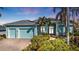 Charming light blue home with a brick driveway, lush landscaping and a two-car garage at 960 Messina Dr, Punta Gorda, FL 33950