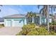 Charming light blue home with a brick driveway, lush landscaping and a two-car garage at 960 Messina Dr, Punta Gorda, FL 33950