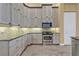 A modern kitchen with stainless steel appliances, updated cabinets, and stone backsplash at 960 Messina Dr, Punta Gorda, FL 33950