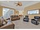 Spacious living room featuring tile floors, large windows, ceiling fan, and comfortable leather seating at 960 Messina Dr, Punta Gorda, FL 33950