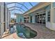 Screened-in pool area with a kidney shaped pool, hot tub, and access to outdoor kitchen at 960 Messina Dr, Punta Gorda, FL 33950