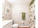 Well-lit bathroom with a tropical-themed shower curtain, wood flooring, and neutral wall colors at 1080 Bal Harbor Blvd # 4D, Punta Gorda, FL 33950