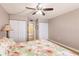 This bedroom features a ceiling fan, two closets, a floral themed bedspread, and an ensuite bathroom at 1080 Bal Harbor Blvd # 4D, Punta Gorda, FL 33950
