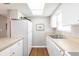 A well-lit kitchen featuring white appliances, cabinets, and countertops with modern wood flooring at 1080 Bal Harbor Blvd # 4D, Punta Gorda, FL 33950