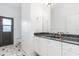 Well-lit bathroom featuring a sleek vanity with a dark countertop and contrasting cabinets, plus a door to the outside at 1105 Rum Cay Ct, Punta Gorda, FL 33950