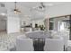 Open concept dining room with white chairs, stone tile floors, and adjacent kitchen at 1105 Rum Cay Ct, Punta Gorda, FL 33950