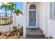A welcoming covered entry with a light blue door, decorative plants, and pavers at 1105 Rum Cay Ct, Punta Gorda, FL 33950