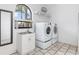 Bright laundry room featuring a sink and an arched window, with a washer and dryer to make laundry simple at 1105 Rum Cay Ct, Punta Gorda, FL 33950