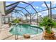 Enclosed swimming pool with rock waterfall feature and tropical landscaping at 1105 Rum Cay Ct, Punta Gorda, FL 33950