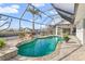 Enclosed swimming pool with rock waterfall feature and tropical landscaping at 1105 Rum Cay Ct, Punta Gorda, FL 33950