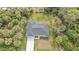 Aerial view of home showcasing the roof, surrounded by a lush, green lawn and tropical trees at 1117 Vernon Ave, Port Charlotte, FL 33948
