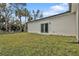 Home's backyard features a grassy area, slider, and exterior that adds to this property's charm at 1117 Vernon Ave, Port Charlotte, FL 33948