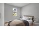 A cozy bedroom offers a comfy bed with soft pillows and a view to the outside through a sunlit window at 1117 Vernon Ave, Port Charlotte, FL 33948