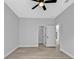 A serene bedroom features wood-look floors, an overhead fan, a walk-in closet, and neutral grey walls at 1117 Vernon Ave, Port Charlotte, FL 33948