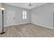 An empty bedroom with neutral walls, wood-look vinyl floors, and a large window letting in natural light at 1117 Vernon Ave, Port Charlotte, FL 33948