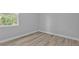 An empty bedroom is bright with natural light showcasing new vinyl flooring at 1117 Vernon Ave, Port Charlotte, FL 33948