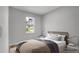 A cozy bedroom offers a comfy bed with soft pillows and a view to the outside through a sunlit window at 1117 Vernon Ave, Port Charlotte, FL 33948