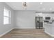 Open concept dining room with neutral walls and wood-look vinyl floors, with kitchen in the background at 1117 Vernon Ave, Port Charlotte, FL 33948