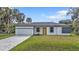 Charming single-story home with a well-maintained lawn, attached garage, and a bright yellow front door at 1117 Vernon Ave, Port Charlotte, FL 33948