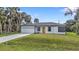 Charming single-story home with a well-maintained lawn, attached garage, and a bright yellow front door at 1117 Vernon Ave, Port Charlotte, FL 33948