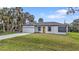 Charming single-story home with a well-maintained lawn, attached garage, and a bright yellow front door at 1117 Vernon Ave, Port Charlotte, FL 33948