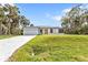 Charming single-story home with a well-manicured lawn, driveway, and a bright yellow front door at 1117 Vernon Ave, Port Charlotte, FL 33948